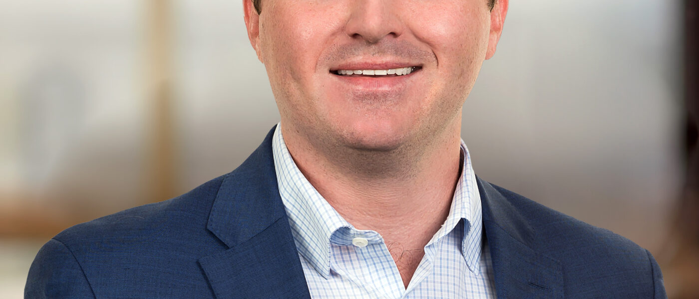 Professional headshot of Christian Amato, Capital Markets Associate at Brennan Investment Group, smiling in business attire.